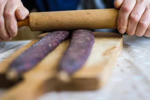 Closeup of man hands rolling over homemade sausages to make them flat for dry Stock Photos