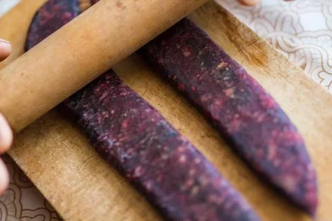 Closeup of man hands rolling over homemade sausages to make them flat for dry Stock Photos