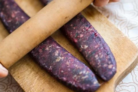 Closeup of man hands rolling over homemade sausages to make them flat for dry Stock Photos