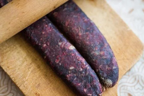 Closeup of man hands rolling over homemade sausages to make them flat for dry Stock Photos