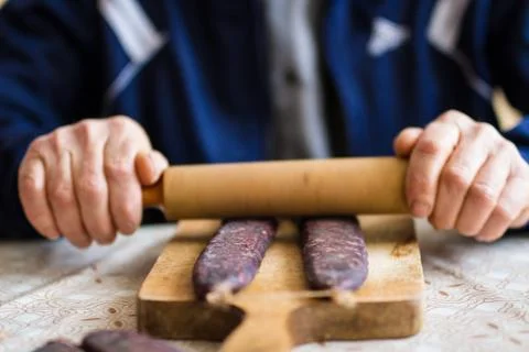 Closeup of man hands rolling over homemade sausages to make them flat for dry Foto stock