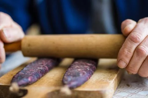 Closeup of man hands rolling over homemade sausages to make them flat for dry Stock-Fotos