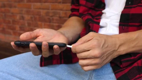Closeup Of Man Hands With Smart Phone And Headphones Listening Music Stockbeeldmateriaal 84958475