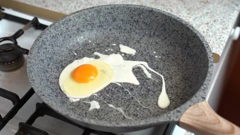 Closeup man hands sprinkle pepper from the mill scrambled in a frying pan Stock Footage 131895651