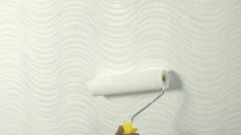 Closeup of man hands using paint roller while painting wallpaper Stock Footage 142539050