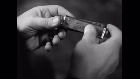 Closeup of man holding broken harmonica, 1930s Stock Footage 260257401