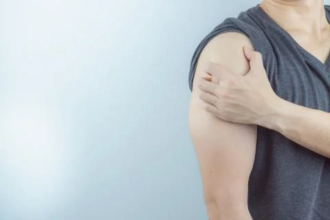 Closeup man holds his arm pain on white background. Health care and medical c Stock Photos