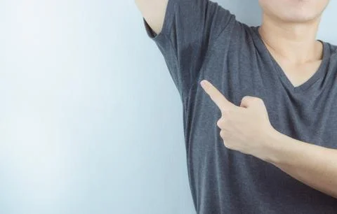 Closeup man with hyperhidrosis sweating very badly under armpit and left stai Stock Photos
