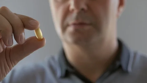 Closeup of a man ingesting a pill and drinking it with a glass of water Stock Footage 111708017