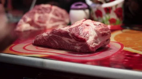 Closeup of a man in the kitchen cut the pork on a cutting Board Stock Footage 71114197