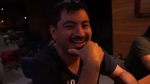 Closeup of a man laughing and talking to the camera and having a sip of beer bet 库存影片 199515485