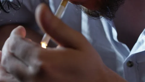 Closeup of a man lighting up a cigarette with a lighter Video stock 135783776