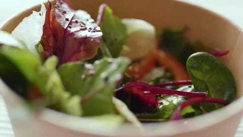 Closeup of man making a fresh healthy salad in a zero waste container to go.  Video stock 305096080