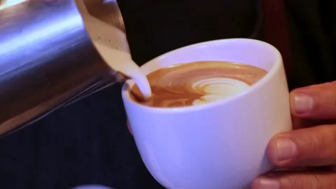Closeup of a man making a heart pattern in a glass of coffee in his hands Stock Footage 240941543