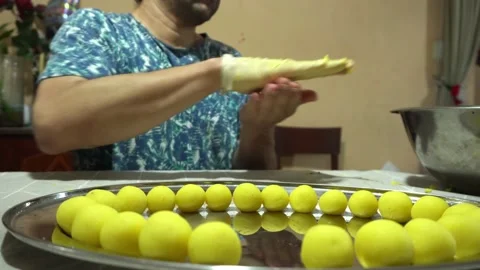 Closeup of a man making little balls of Causa de Lima with his hands on a metal 스톡 동영상 171946012