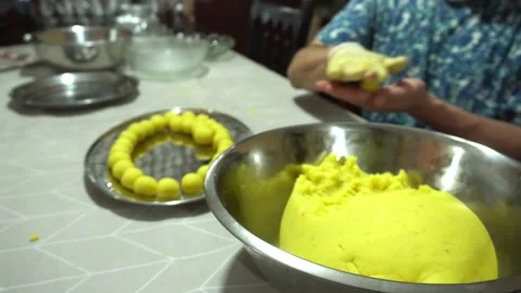 Closeup of a man making little balls of Causa de Lima with his hands on a metal Stock Footage 171996201