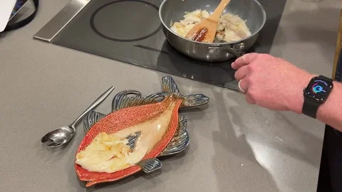 Closeup of man moving cooked fish filets from pan to serving platter Stock Footage 273176551
