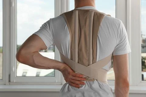 Closeup of man with orthopedic corset indoors, back view Stock Photos