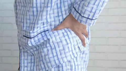 Closeup Man with pajama Feels Back Pain on the Bed at Home, Rubs Lower Back Poor 스톡 동영상 336585288