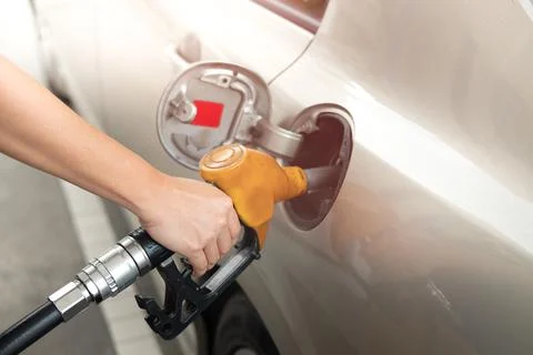 Closeup of man pumping gasoline fuel in car at gas station. Fuel nozzle with Stock Photos