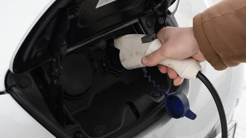 Closeup of a man putting an e-car on recharging Stock Footage 101687409