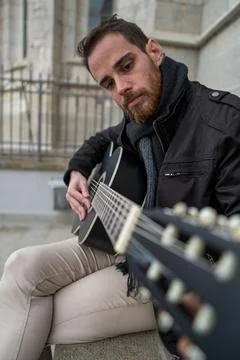 Closeup of man with red beard learning to play guitar. Vertical Foto stock