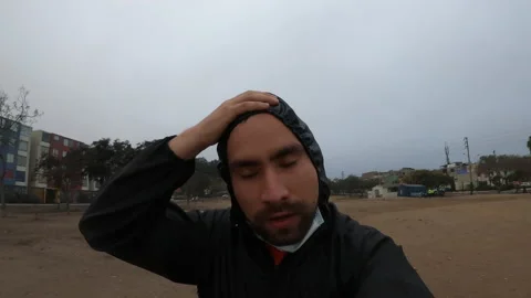 Closeup of a man removing his mask and biosafety suit to cool off while running Video stock 140572057