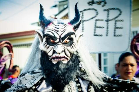 Closeup man in scary devil mask and costume poses for photo at dominican carn Stock Photos