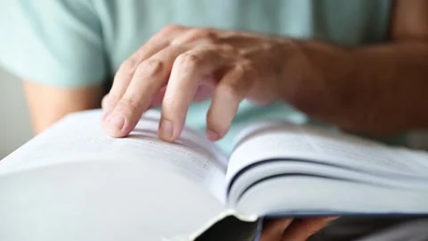 Closeup of man searching for the term in the dictionary, finger pointing to.. Stock Footage 290102595