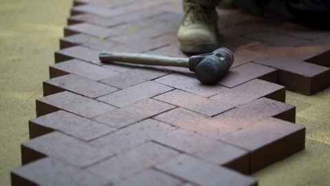 Closeup of a man setting brick pavers into place in a herringbone pattern. Stock Footage 82177277