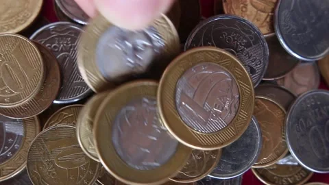 Closeup from a man stacking brazilian Real coins over a table during inflation p Stock-Footage 229809473