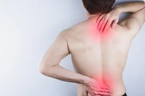 Closeup man suffering from lower back and neck pain with red spot. Health car Foto stock