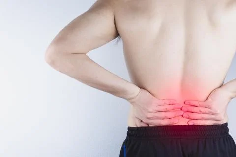 Closeup man suffering from lower back pain with red spot. Health care and med Stock Photos