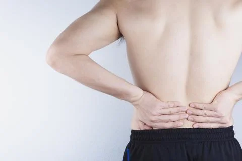 Closeup man suffering from lower back pain. Health care and medical concept. Stock Photos