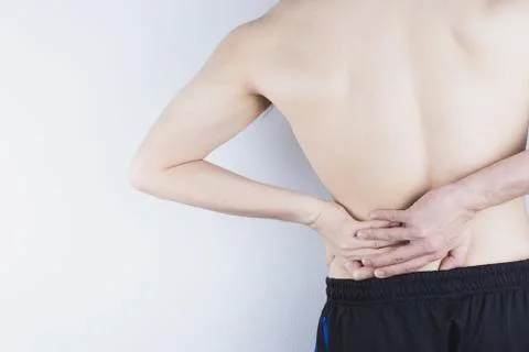 Closeup man suffering from lower back pain. Health care and medical concept. Stock Photos