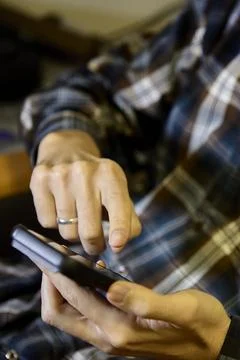 Closeup of man tapping smartphone screen indoors Stock Photos