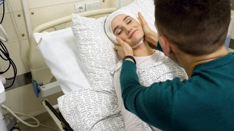 Closeup of man touching head of his girlfriend bandaged after plastic surgery 4K Stock Footage 123214184