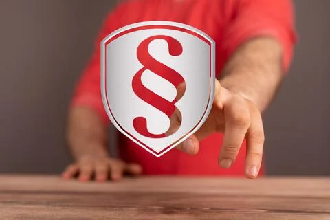 Closeup of a man touching a rendering of a paragraph sign on a shield Foto stock