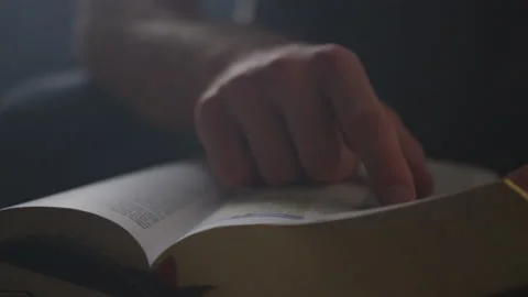 Closeup of a Man Tracing Pages of the Holy Scriptures with His Finger Stock Footage 208746965