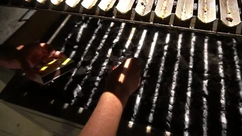Closeup of a man trying to light a lighter with INTI matches between coals and Видео 181917399