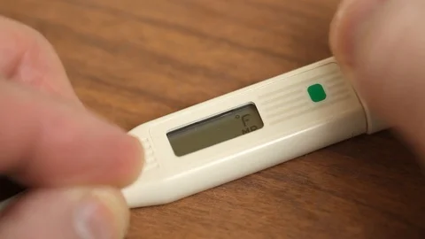 Closeup of a Man Turning on Digital Thermometer Stock Footage 103551111