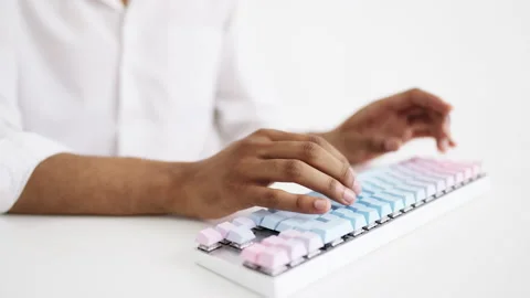 Closeup of man typing on computer keyboard in all white room, work process Stock Footage 235205993