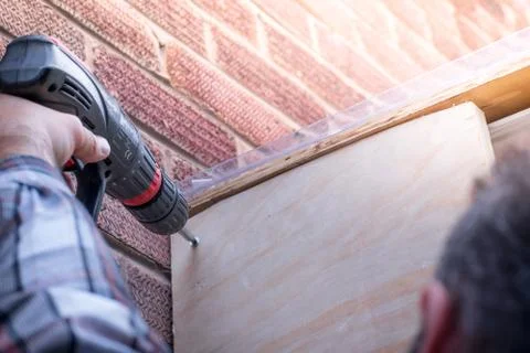 Closeup of Man Using a Power Drill building a house porch at home Stock Photos