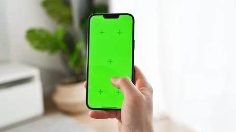 Closeup of man using smartphone with green screen tapping on the screen. Mobile Stock Photos
