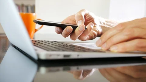 Closeup of man using smartphone with laptop Vídeo Stock 95391417