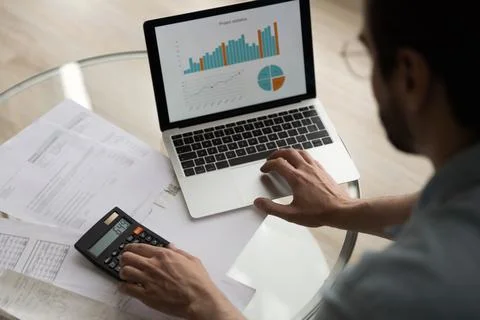 Closeup man verifies data financial reports with graphs on computer Stock Photos