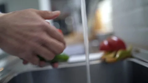 Closeup of man washing vegetables under tap Stock Footage 103287357