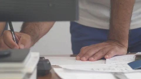 Closeup of a man working on a desk writes over a paper project Video stock 118004297