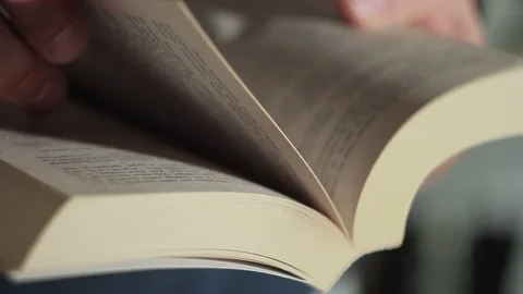 Closeup of a man's hand flipping through a paper book 스톡 동영상 86216707