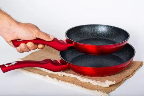 Closeup of man's hand holding empty frying pans. Concept of food preparation Foto stock